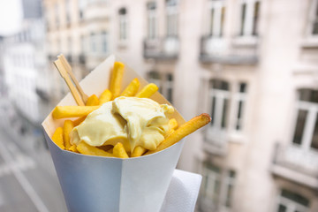 Belgian fries with mayonnaise on blurred street background