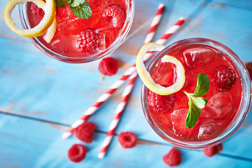 two colorful raspberry cocktails with mint and lemon 