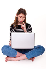 Naklejka premium Young Woman with PC hand on chin E-commerce Stock Image