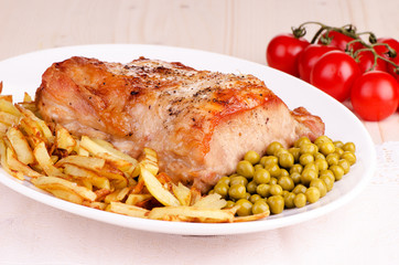 Roasted meat with vegetables on a white plate