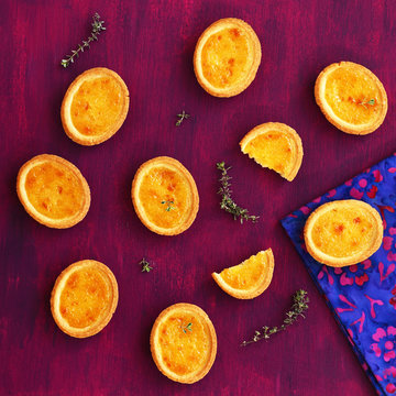 Mini lemon tarts with thyme on deep lilac background