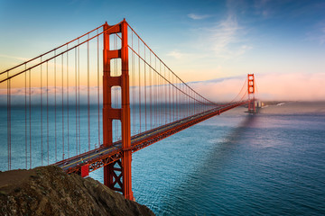 Fototapeta na wymiar Sunset view of the Golden Gate Bridge and fog from Battery Spenc