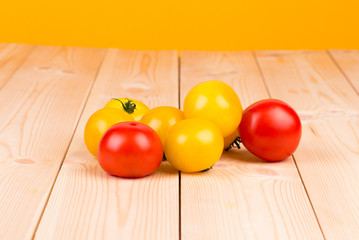 Yellow and red tomatoes on the wood.