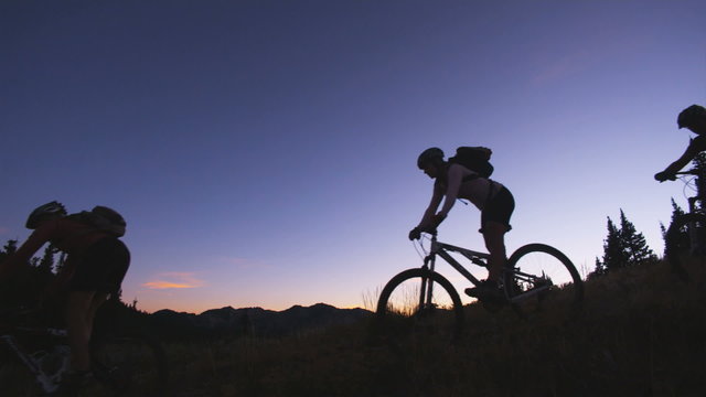 mountain bikers riding at sunset