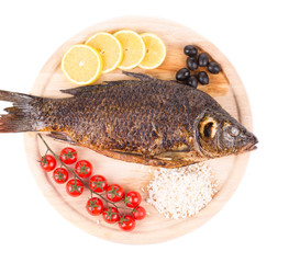 Grilled carp fish with lemon and tomatoes.
