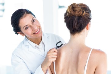 Doctor examining patient with magnifying glass