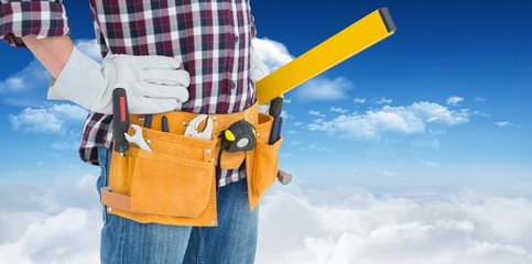repairman wearing tool belt while standing with hands on hips