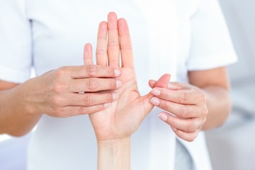 Physiotherapist examining her patients hand
