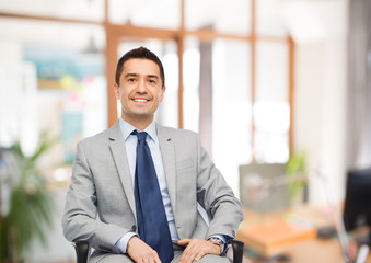 happy businessman sitting in office chair