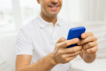 close up of happy man with smartphone at home