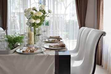 dining wooden table and comfortable chairs in modern home with e