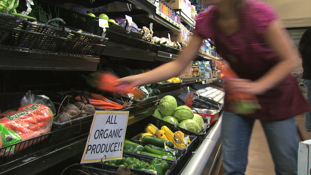 Grocery Clerk Stocking Organic Vegetables