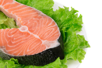 Raw salmon steak with lettuce salad.
