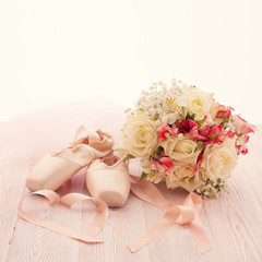 Ballet shoes. Pointe shoes, bouquet flowers on wooden desk
