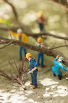 Miniature workmen clearing fallen trees