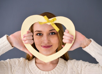 Closeup portrait of young female holding heart