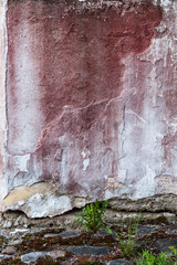 Broken concrete wall and faded red paint