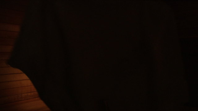 A woman taking her towel off in a sauna