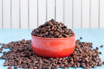Pine nuts in a ceramic bowl on light background. Cedar nut close