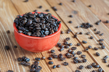 Fototapeta na wymiar Coffee beans in red bowl on wooden background