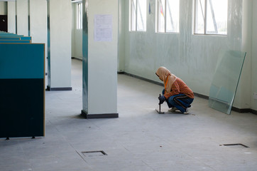Female worker clean up debris on the floor