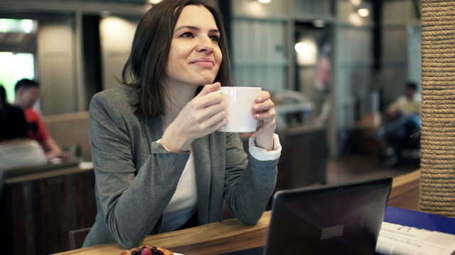 Young, attractive businesswoman drinking coffee in cafe
