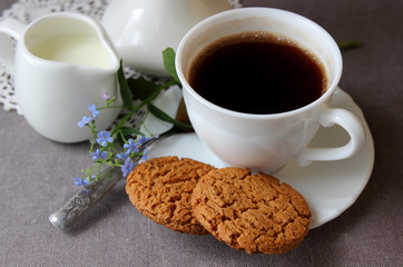 A cup of coffee, a sprig of nezabudok and oatmeal cookies.