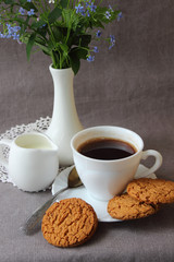 A cup of coffee, spring flowers and oatmeal cookies.