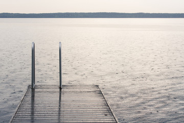 Fototapeta premium Rain Pouring Down and Rippling Surface of a Lake.