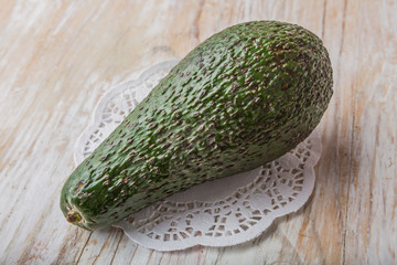 Green avocado on a white wooden table