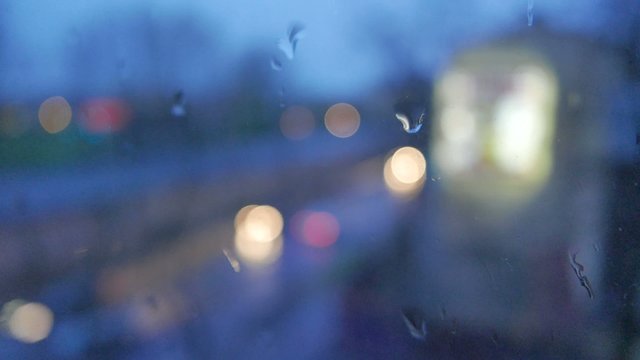 Abstract blurs of lights and rain drops through window
