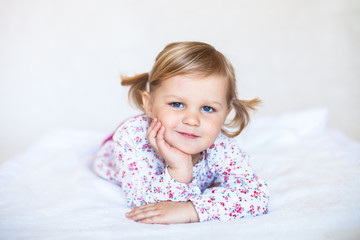 Fototapeta premium Little cute baby girl lying on the white blanket