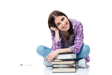 Happy woman sitting on the floor with books
