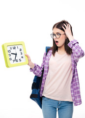 Surprised young female student looking on clock