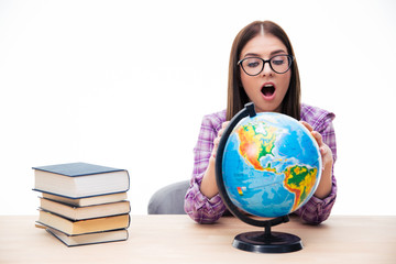Amazed young female student looking at globe