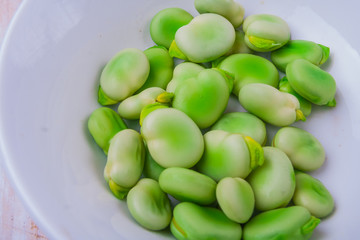 Fresh broad bean in white bowl