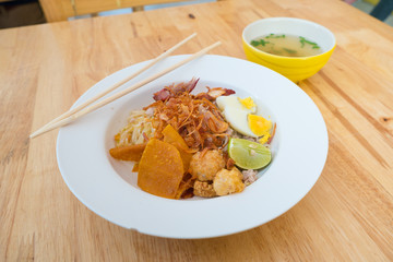 Asian dry noodle with garnish on the wooden background
