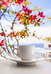 A cup of coffee on table with Italian town at the background