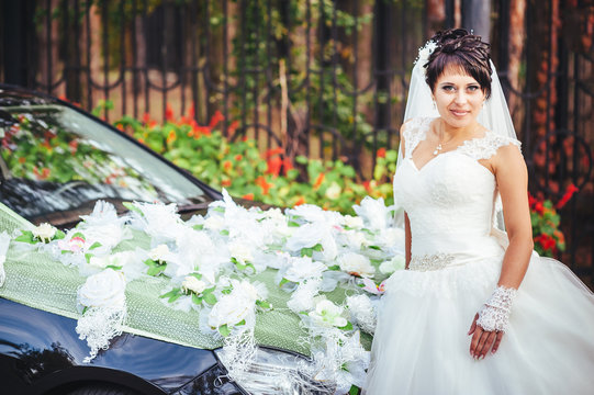 The bride near a black wedding car