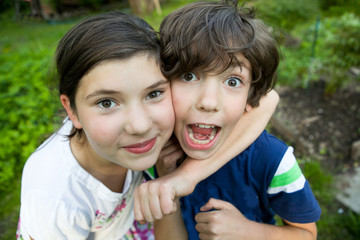siblings preteen boy and girl together close up portrait on the summer green background