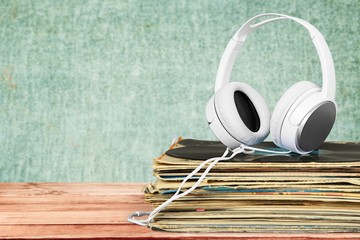 Vinyl. Golden headphones lying on the stack of vinyle records.