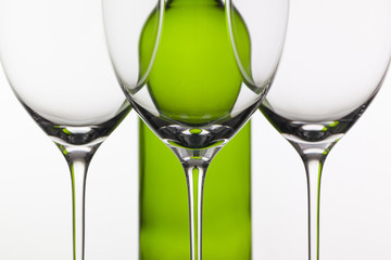 Three empty glasses of wine and green bottle