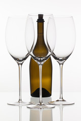Three empty glasses of wine and brown bottle