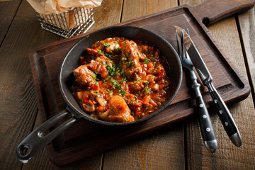Fried meat in a frying pan tomato sauce