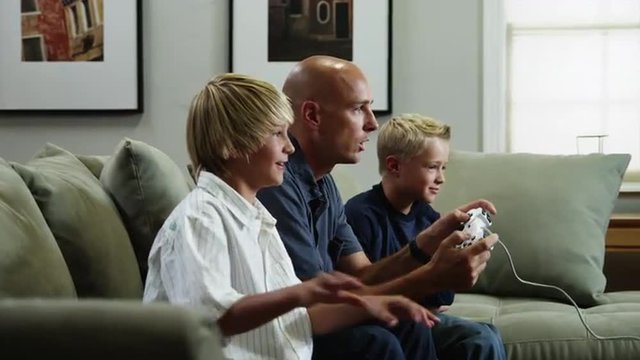 ZI MS Father with two sons (8-9, 10-11) playing video game / Orem, Utah, USA