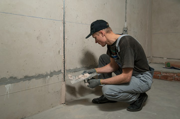 Woker fixes a guide to align the walls with stucco