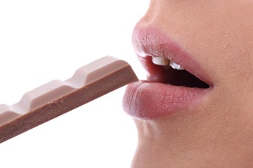 Junge Frau isst Schokolade (Nahaufnahme auf weißem Hintergrund)
