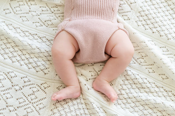Tiny little newborn baby's feet in woolen shorts