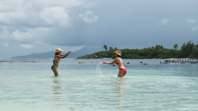 two women splashing in the ocean