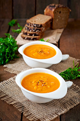 Delicious cream of pumpkin soup in a bowl on wooden table